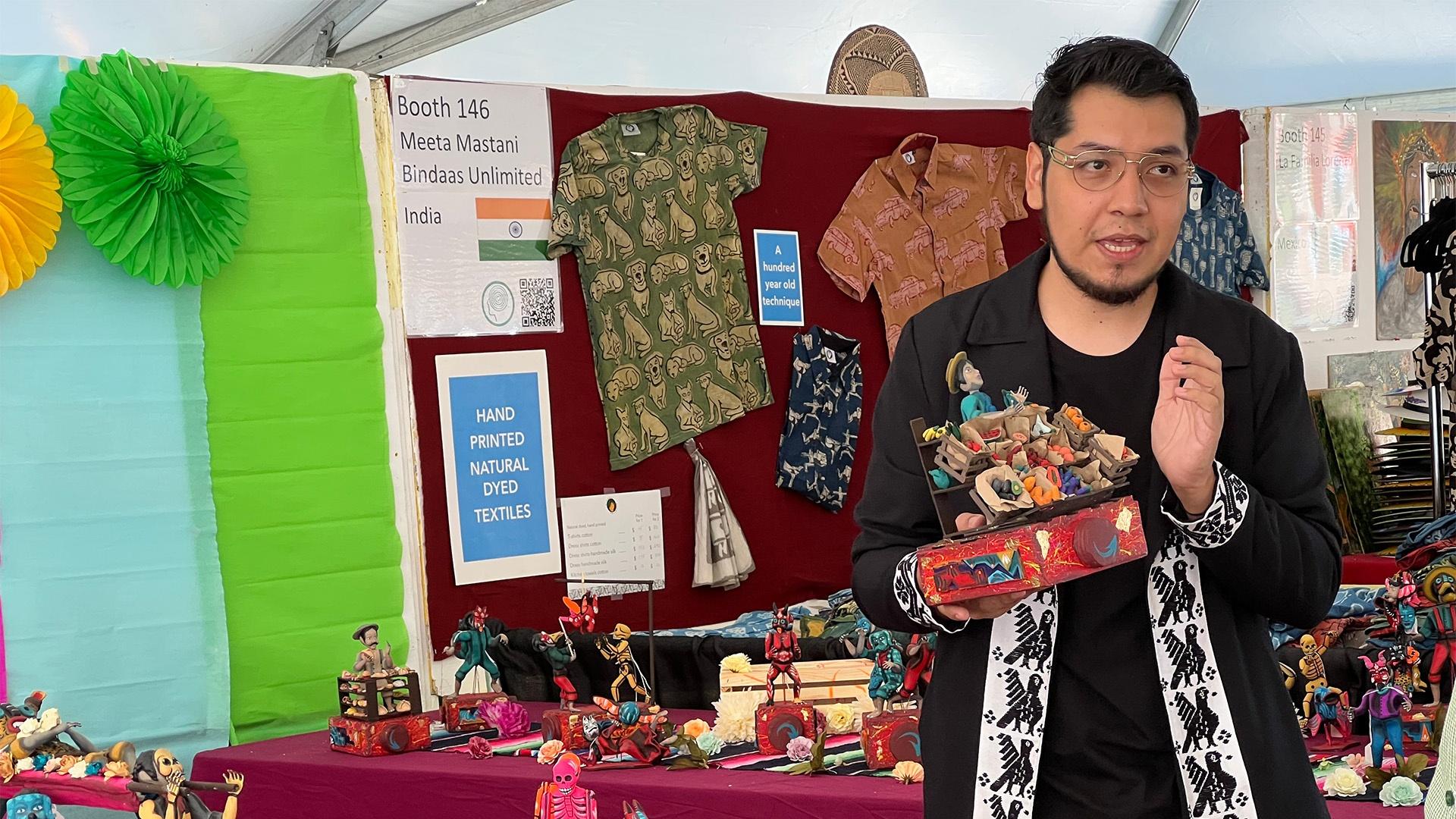 JOSUÉ ELEAZAR CASTRO RAZO holds his miniature sculpture at the International Folk Art Market