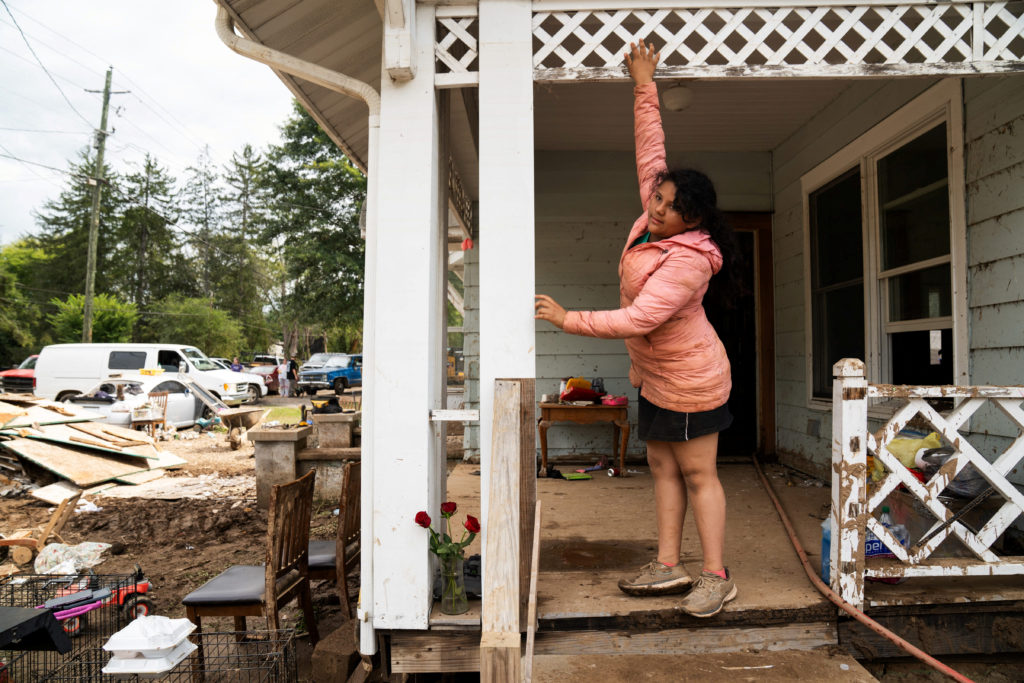 Ady Asenciocoado, 10, shows how high the water level got in her home