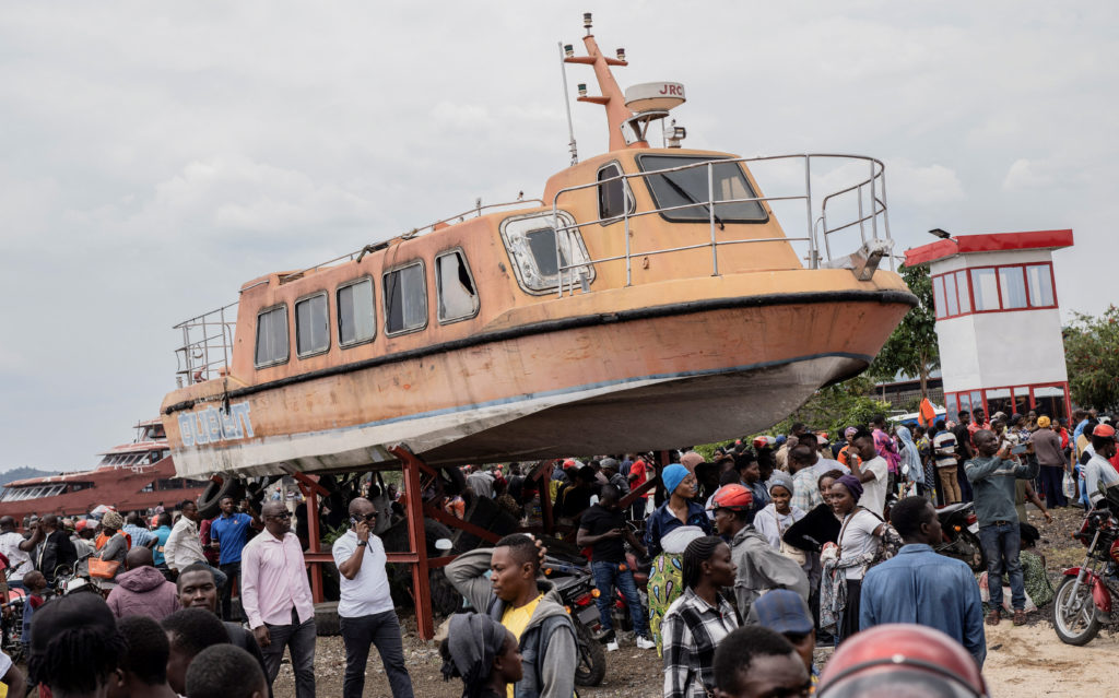 Residents gather to witness the search and rescue mission after a boat ferrying passengers and goods from the Minova villa...