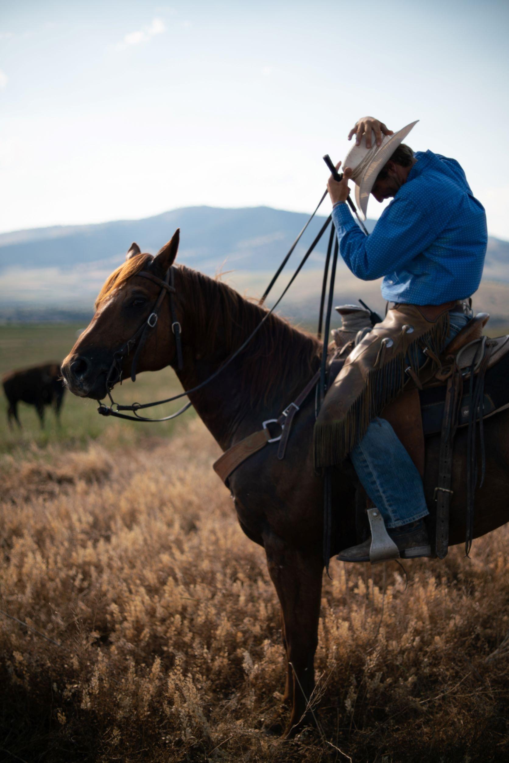 Zanen Pitts adjusts hat while on a horse