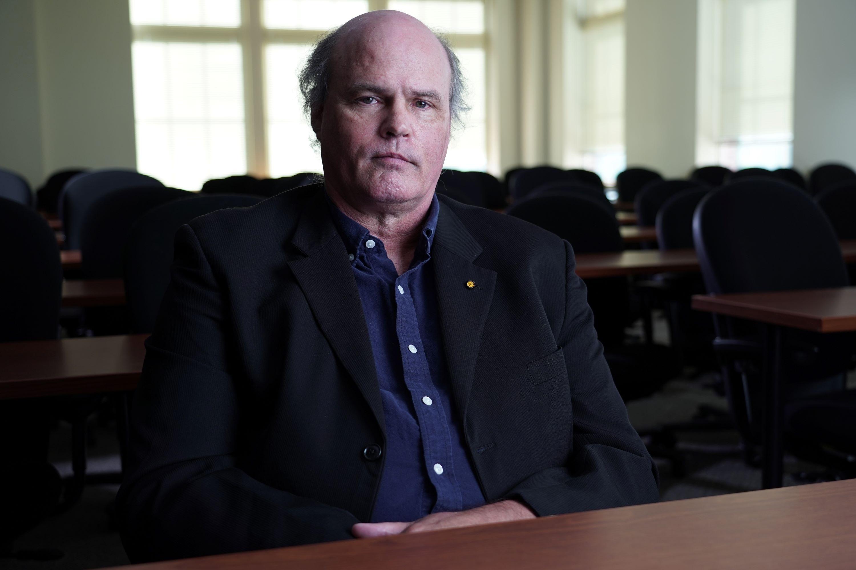 Dr. Thomas Joiner sits in a classroom