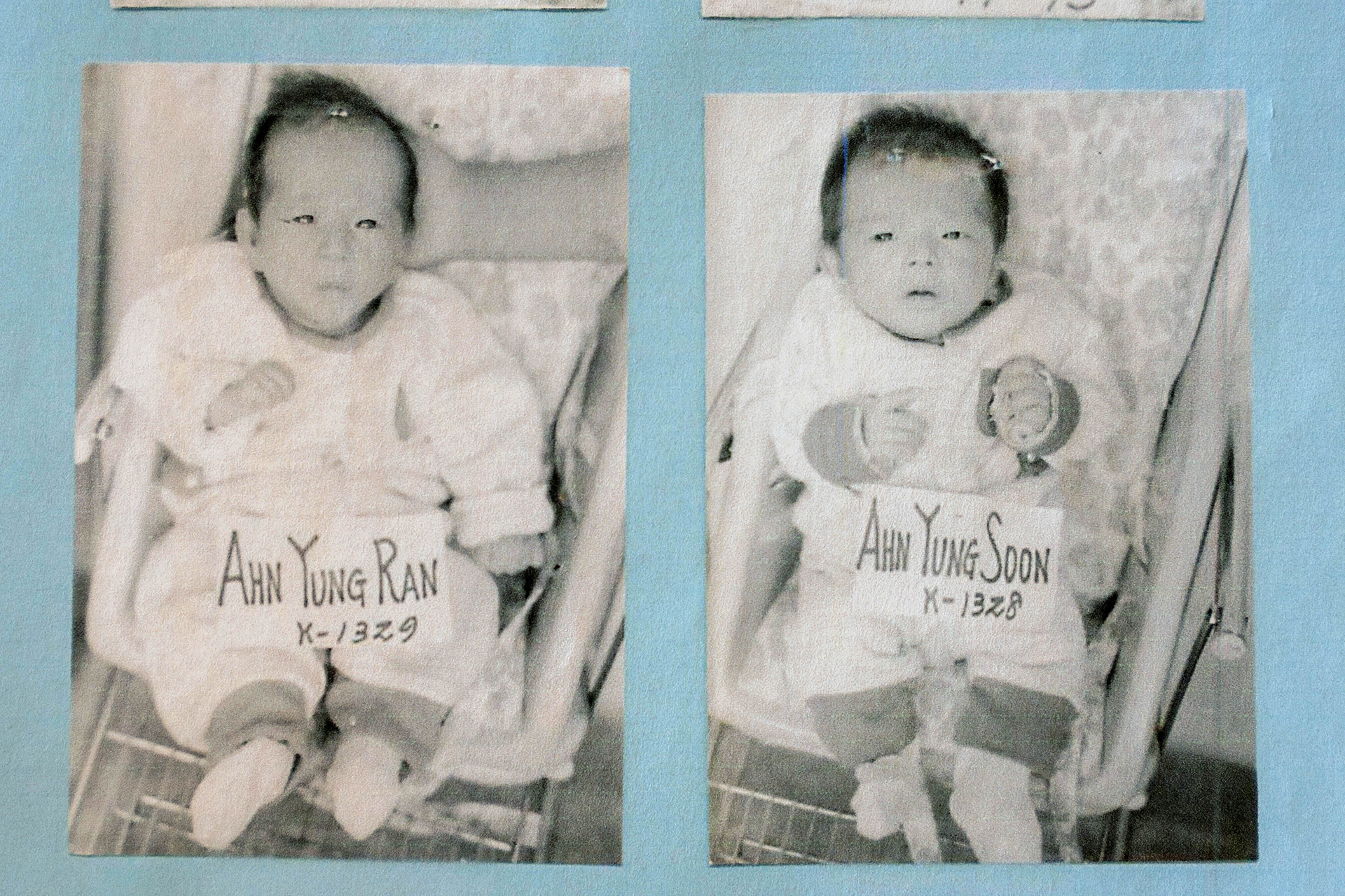 Baby photos of twin sisters Dee Iraca and Becca Webster are displayed in a photo album.