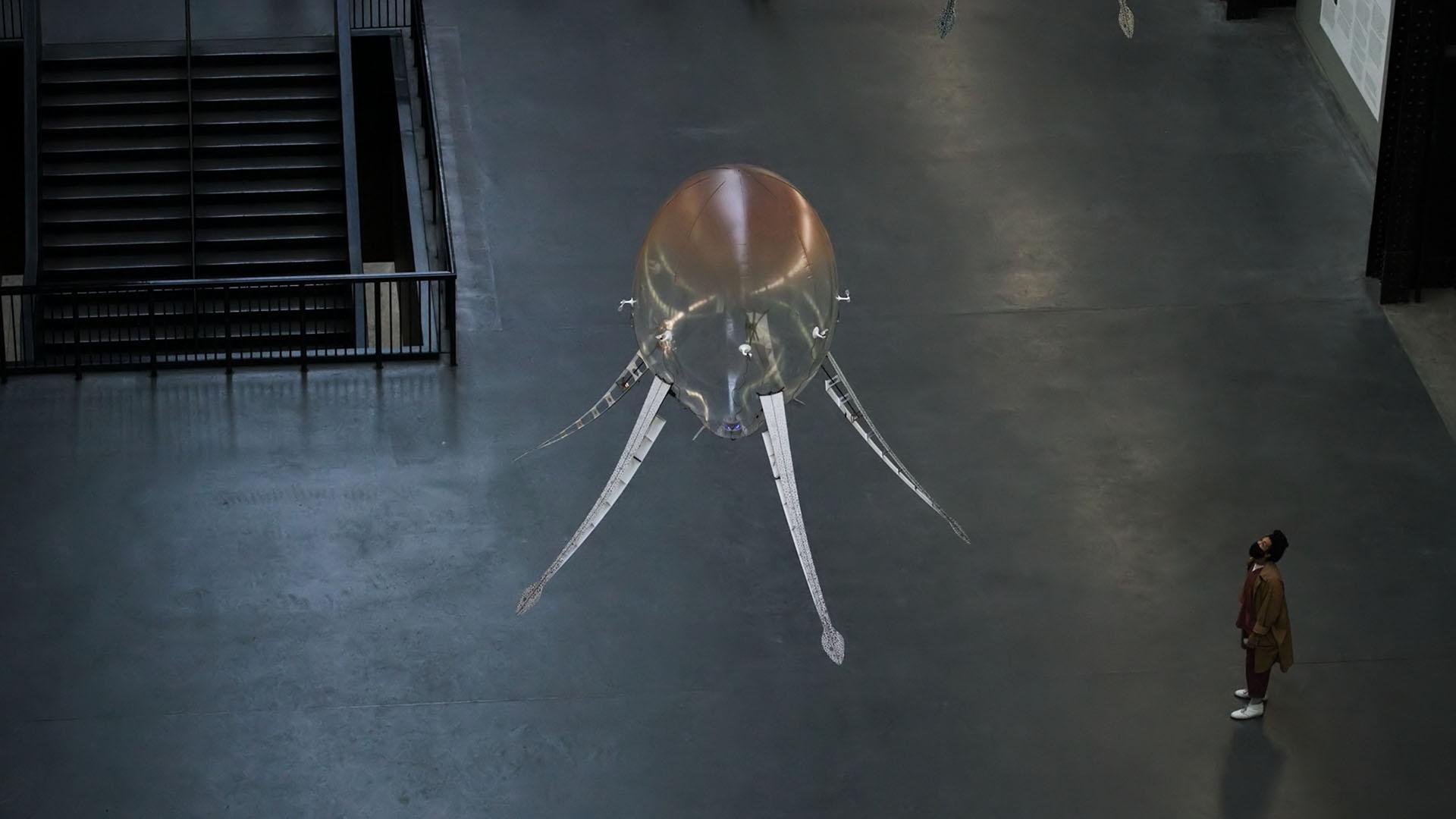 A viewer looking up at Anicka Yi's Turbine Hall commission, "In Love with the World" at Tate Modern.